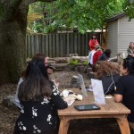 playground tour participants at wooden picnic tables